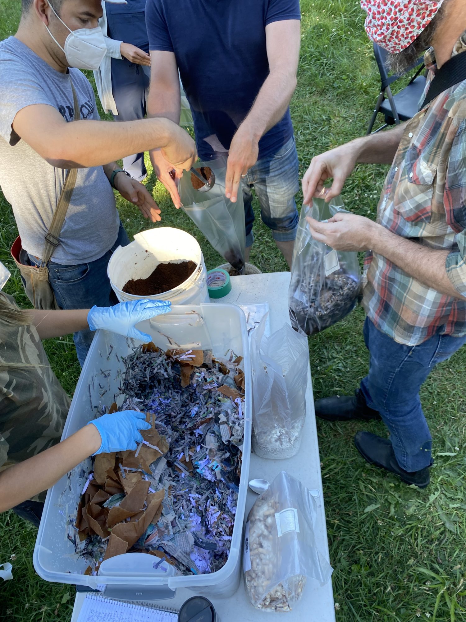 Workshop attendees fill their grow bags with a substrate of spent coffee grounds and shredded paper. Photo credit: Tirzah Vogels.